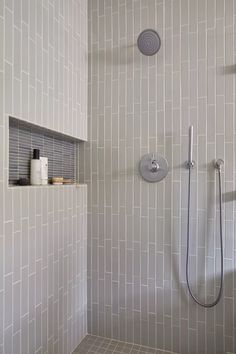 a bathroom with a shower head and hand held shower faucet in the corner