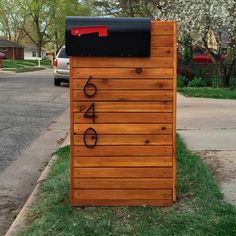 a mailbox sitting on the side of a street next to a sidewalk and trees