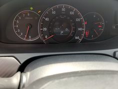 the dashboard of a car with three speedometers