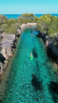 two people are kayaking in clear blue water