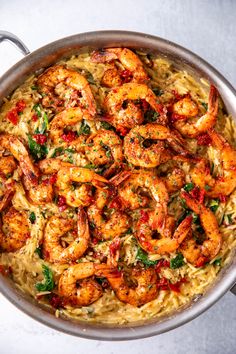 a pan filled with pasta and shrimp on top of a table