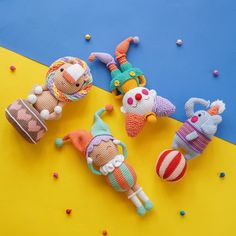 three knitted toys laying on top of a yellow and blue surface