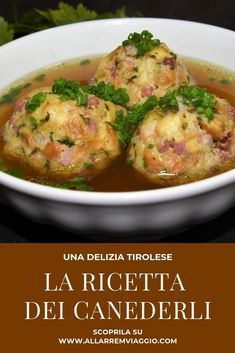 a white bowl filled with soup and meatballs on top of a wooden table next to cilantro