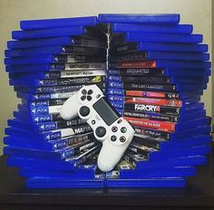 a stack of video game controllers sitting on top of each other in front of a pile of dvds