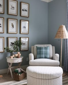 a living room with blue walls and pictures on the wall above the chair is a footstool