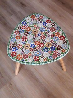 a multicolored mosaic coffee table with wooden legs on the floor in a living room