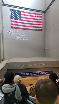 people are standing in front of an american flag