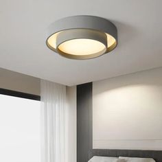 a bed room with a neatly made bed and a round light