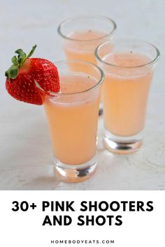 three shot glasses filled with pink shots and a strawberry on the rim, sitting next to each other