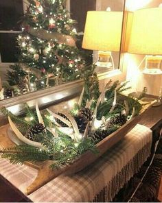 a christmas tree in a wooden sleigh with pine cones and lights on it