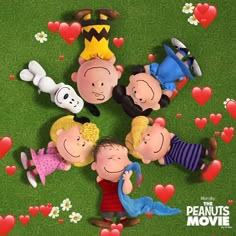 the peanuts movie poster for charlie and his friends with hearts in the grass behind them