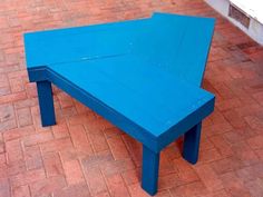 a blue table sitting on top of a brick floor