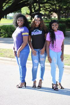 three young women standing next to each other in jeans and t - shirts, with trees in the background