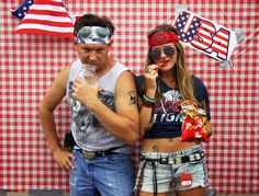 two people standing next to each other in front of a red and white checkered wall