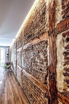 a brick wall in an apartment with wooden floors and hard wood flooring on the side