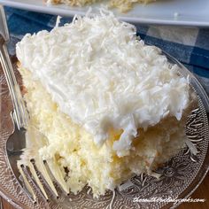 a piece of coconut cake on a plate with a fork