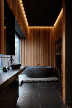 a large bath tub sitting next to a sink in a bathroom under a skylight