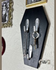 there is a key holder with two keys on it and some other items hanging from the wall