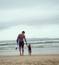 a man and child walking on the beach