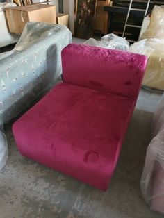 a fuchsia colored chair sitting on top of a floor next to other furniture