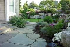 a stone walkway leads to the front door of a house