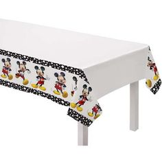 a mickey mouse tablecloth on a white table with black polka dot trimmings