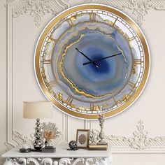 a clock that is on the side of a wall next to a table and lamp