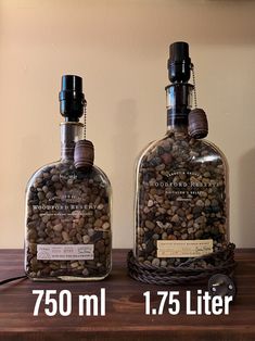 two bottles filled with rocks sitting on top of a wooden table next to each other