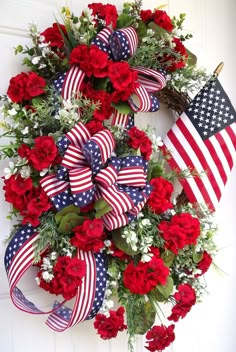 a patriotic wreath with red, white and blue flowers is hung on the front door