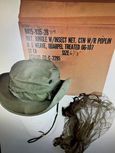 "US VIETNAM ERA OD JUNGLE BOONIE HAT 67/8 OG/107 NEW W MOSQUITO NET NIP.  Condition Brand new in original packing. Original Vietnam Era US Army OG-107 Ripstop 2nd Pattern Jungle  \"Boonie\" Hat - 1969 Contract Date  - 6 7/8 Size - NOS Unissued Condition  Up for Auction is a Vietnam Era US Army OG-107 Ripstop Tropical Jungle \"Boonie\" Hat.  The hat is in NOS Unissued Condition.  The lable has a 1969  Contract Date.  It is a Size 6 7/8.  Very RARE to find with the Original Insect Netting in this Condition.  They don't get any bettern than this one. The 2nd pattern OG-107 boonie hat was made of Quarpel (Quartermaster developed repellent) treated rip-stop cotton poplin, rather than the plain cotton of the original.  Like its predecessor it was issued with an insect net   Head Circumference Ad Green Military Hat With Wide Brim, Green Military Style Wide Brim Hat, Green Wide Brim Military Hat, Green Wide Brim Fishing Hat, Green Wide Brim Hat For Fishing, Green Military Brimmed Hat, Green Military Bucket Hat, Military Style Green Hat For Summer, Green Military Style Bucket Hat