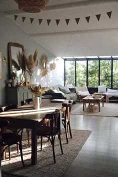 a living room filled with furniture and a large window next to a wooden dining table