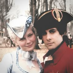 a man and woman are dressed up in historical costumes for an outdoor photo ope