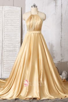 This stunning shiny gold prom dress features halter neckline, classic silhouette of A-line and sleek fabric of silk-like satin. Furthermore, the bold design of low back is full of feminine and alluring accents. Gold Dress Long Classy, Evening Gowns Gold, Gold Dresses Long, Open Back Prom Dress, Elven Dress, A Line Long Dress, Lehenga Designs Simple