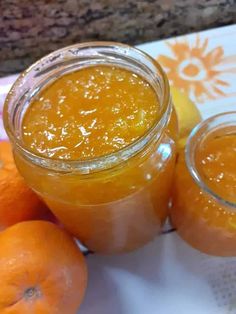 two jars filled with oranges and some fruit