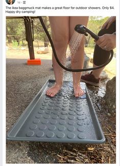 a person standing on top of a metal grate with a hose attached to it