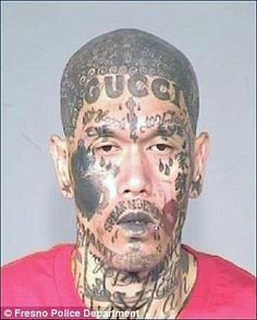 a man with tattoos on his face and chest is shown in this mugshot photo