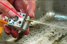 a person is working on an electrical device in a room with cement walls and flooring