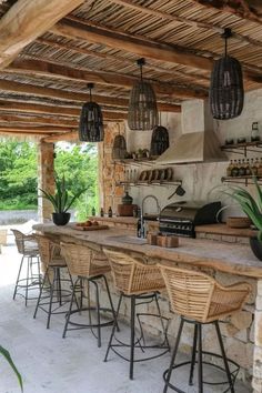 an outdoor kitchen with wicker chairs and bar