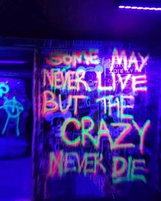 some graffiti on a wall in a dark room with neon lights and the words'one may never live but the crazy men die '