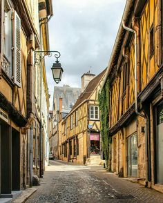 an empty street with old buildings on both sides and a lamp post in the middle