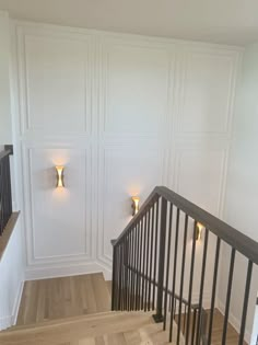 an empty room with some lights on the wall and wood flooring in front of it