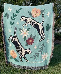 a blanket with two dogs on it in the grass