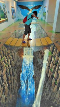 a man standing on top of a waterfall in the middle of a room with paintings