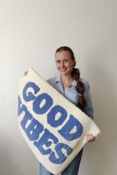 a woman holding a towel with the words good times printed on it in blue and white