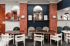 an empty restaurant with tables and chairs in it's dining area, while the walls are painted blue and red