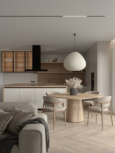 a living room filled with furniture next to a kitchen and dining room table on top of a hard wood floor