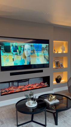 a large flat screen tv mounted on the wall above a fireplace in a living room