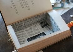 an open book sitting on top of a table next to a pair of orange scissors