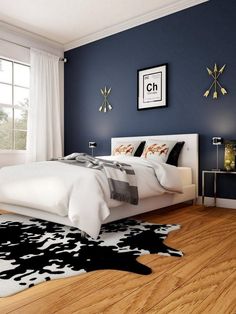 a bedroom with blue walls and white bedding, black and white rug on the floor