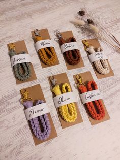 six different colors of beads are displayed on brown tags with name tags attached to them